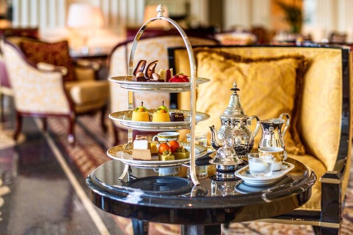 Indulge in a luxurious afternoon tea experience at Palazzo Versace Dubai surrounded by exquisite decor and stunning views savoring an array of delectable treats and elegant teas.